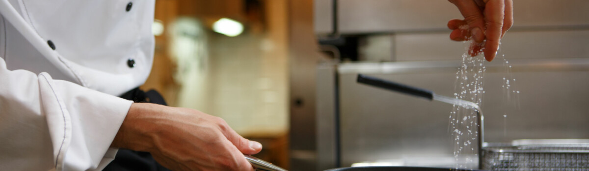 Chef in takeaway cooking food in frying pan