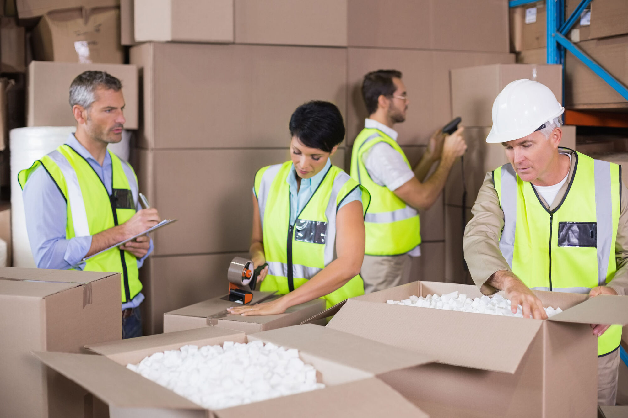 Motivated warehouse workers hard at work after motivating talk Motivated warehouse workers hard at work after motivating talk