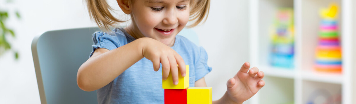 Little girl learning resilience being independent using building blocks