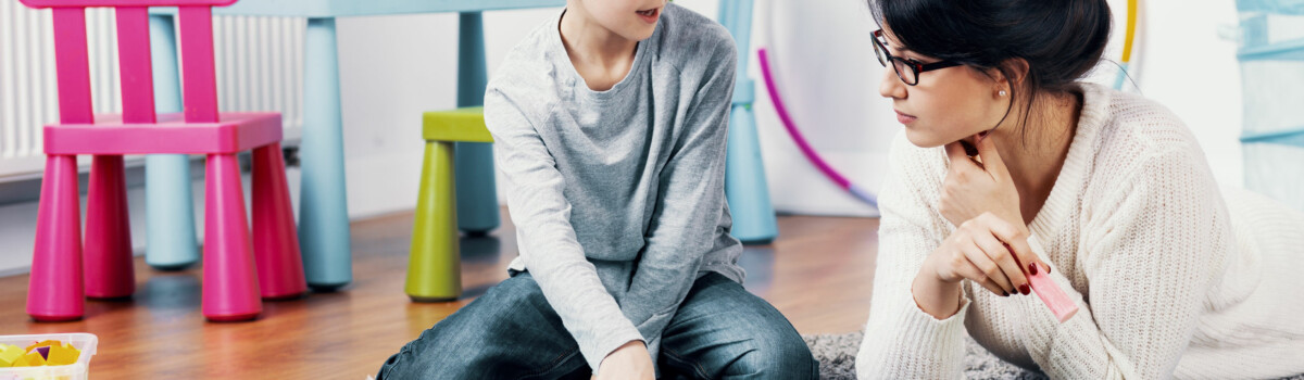 Child sat on carpet talking to teacher about how he is feeling