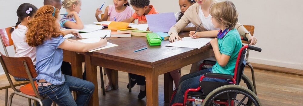 Young teacher sat with children completing equality activities