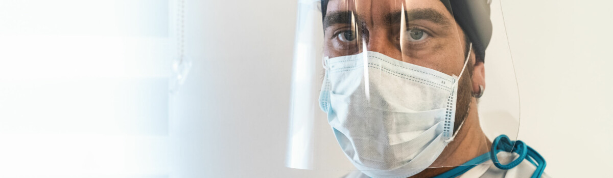 Doctor wearing face PPE before entering hospital room