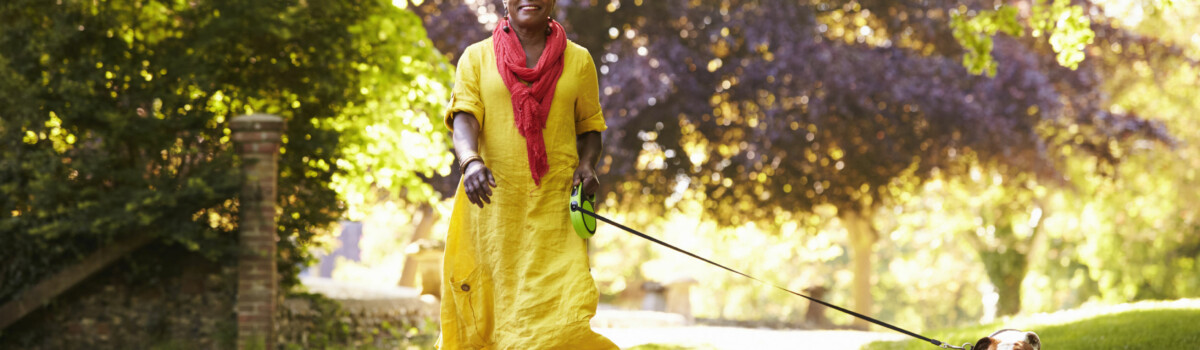 Lady out walking her dog for her exercise and to help maintain positive wellbeing