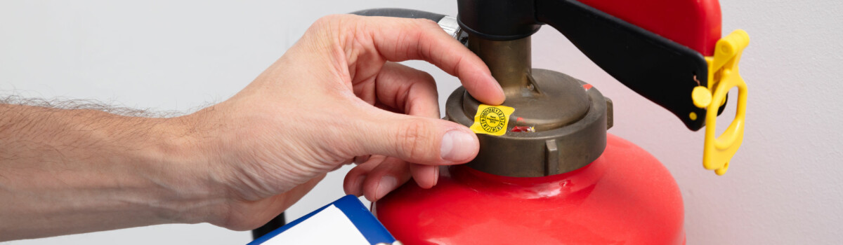 Man inspecting fire extinguishers in care home to ensure they are working