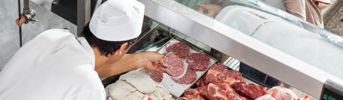 Butcher assisting customer deciding what meat to buy