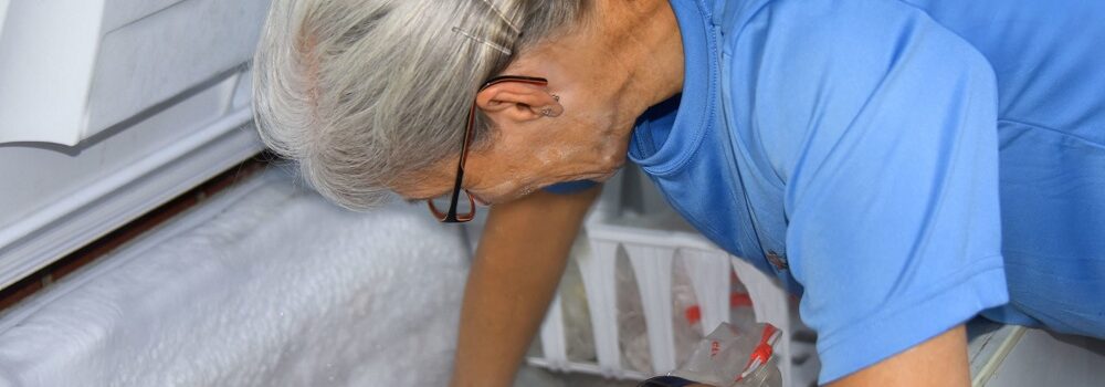 Woman taking frozen meat from the freezer, ready to defrost in the correct way