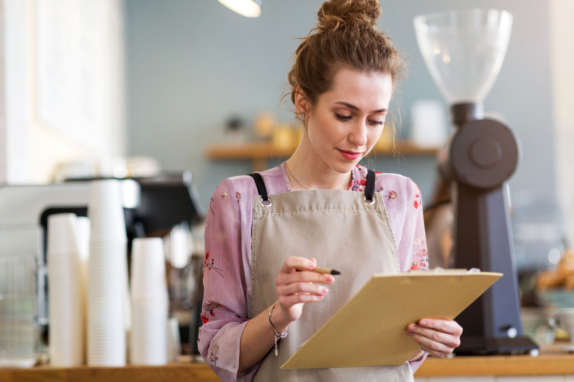 Cafe owner ensuring she follows good hygiene practices while handling food and drink Cafe owner ensuring she follows good hygiene practices while handling food and drink