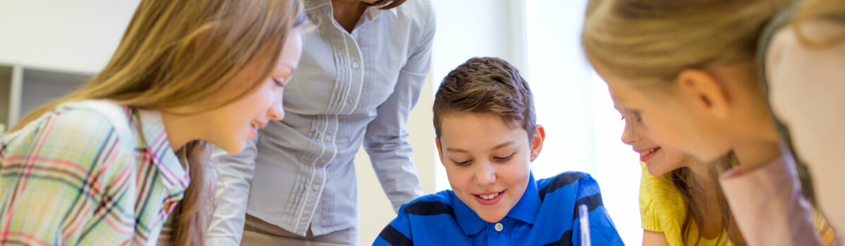 Teacher sat in classroom with children supporting them with their mental health