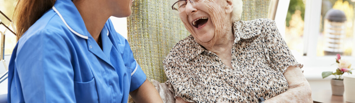 Nurse sat with resident ensuring she is comfortable and happy