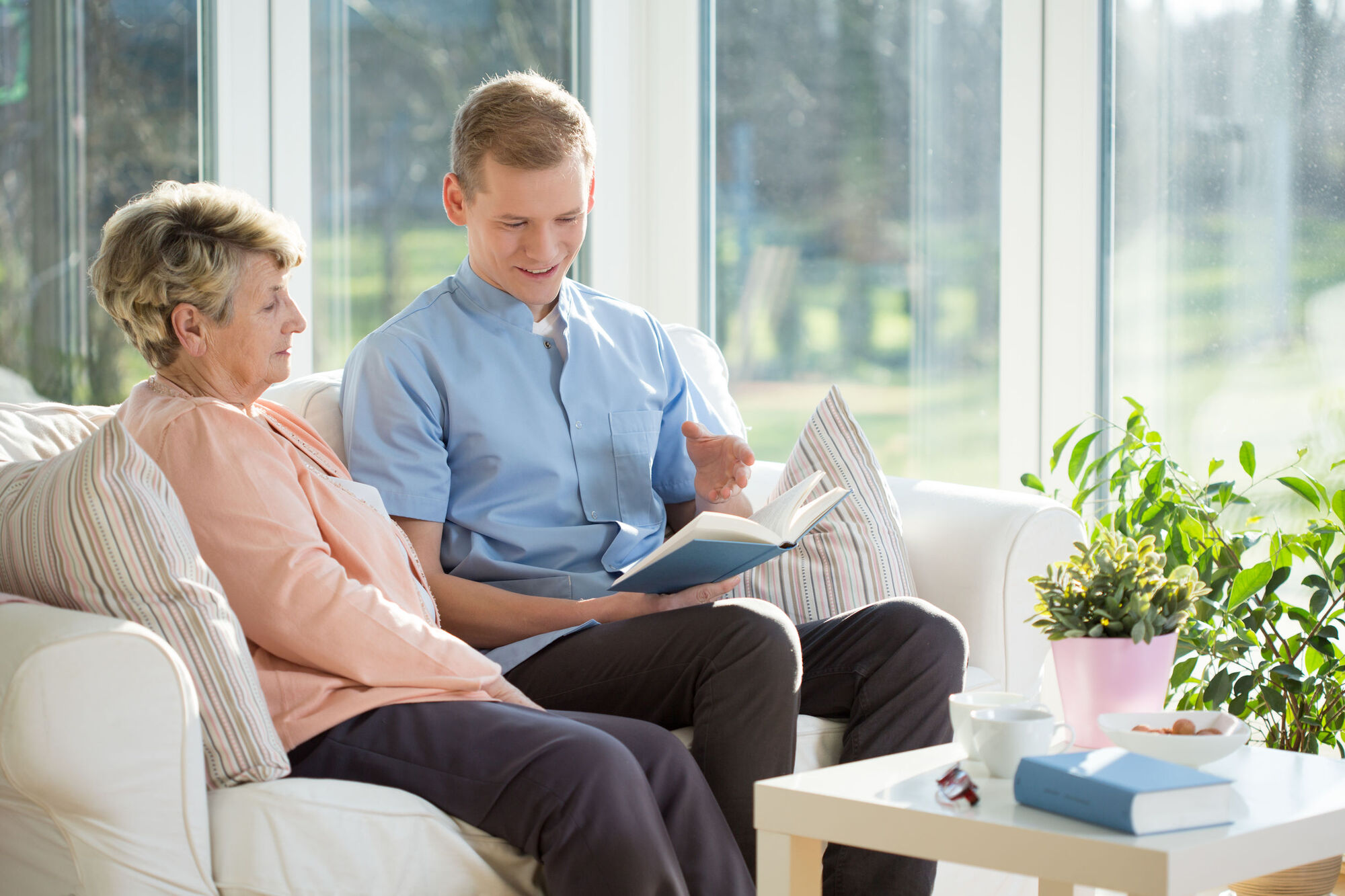 Carer reading to elderly patient Carer reading to elderly patient