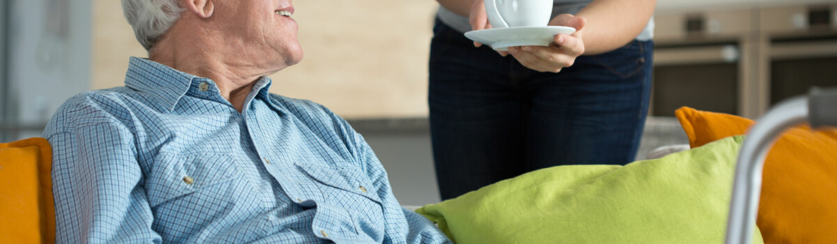 Volunteer in care home providing resident with a hot drink