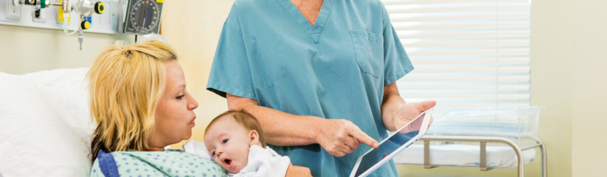 Neonatal midwife talking to mother while holding her baby