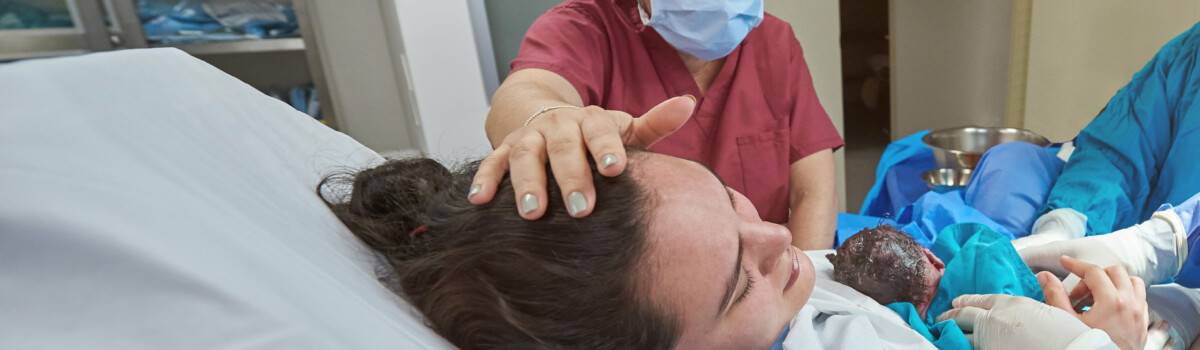 Midwife assisting in c-section delivery