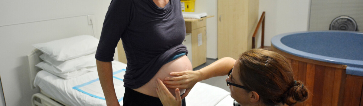 Midwife volunteering on labour ward with delivery of baby