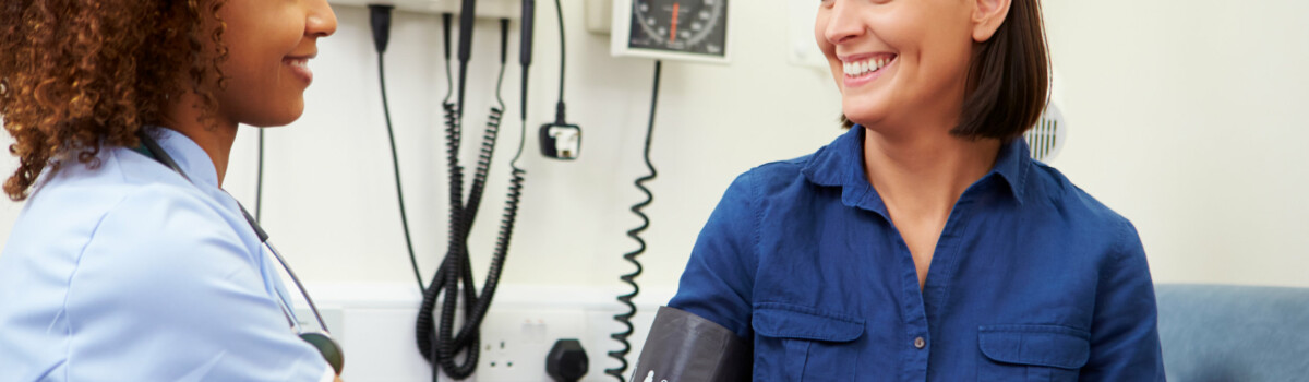 Nurse taking blood pressure of patient at GP surgery