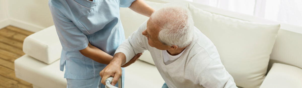 Woman helping man after being trained how to safely assist elderly people