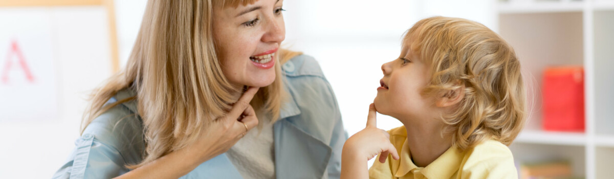 Young boy getting help from a speech therapist