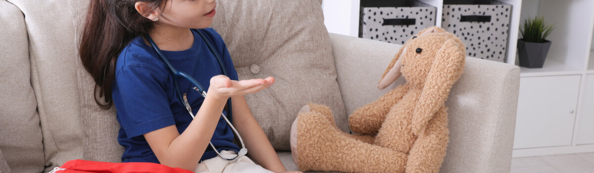 Young girl practising first aid on toy