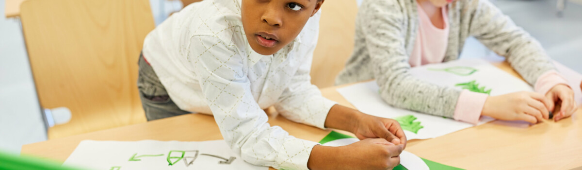 Two children making a project on recycling