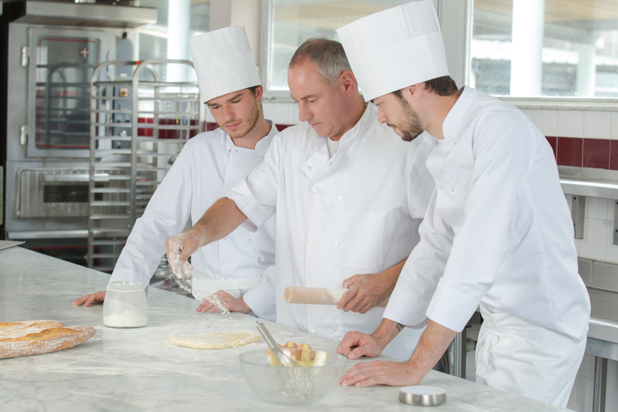 Pastry chef helping some new chefs Pastry chef helping some new chefs