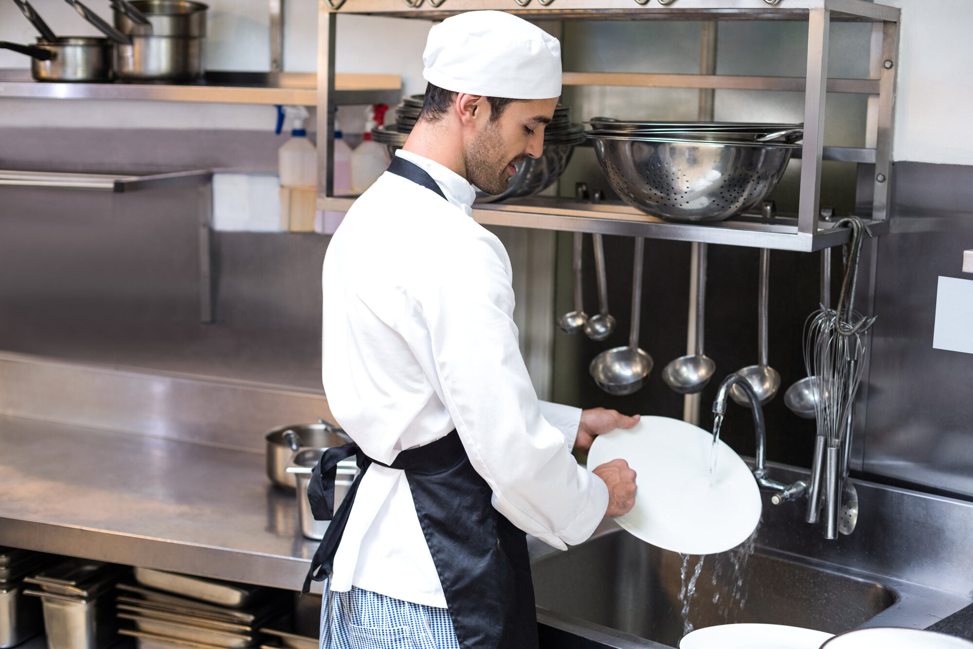 Man washing dishes in a restaurant Man washing dishes in a restaurant