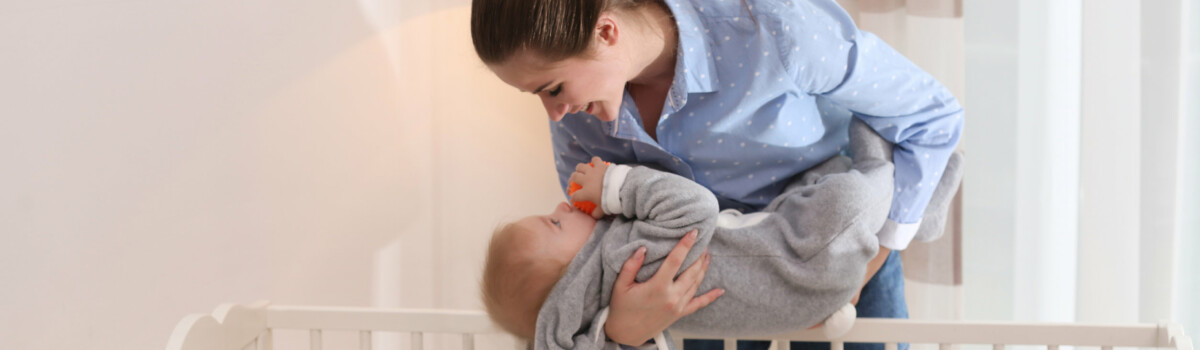 Baby being safely put into a cot