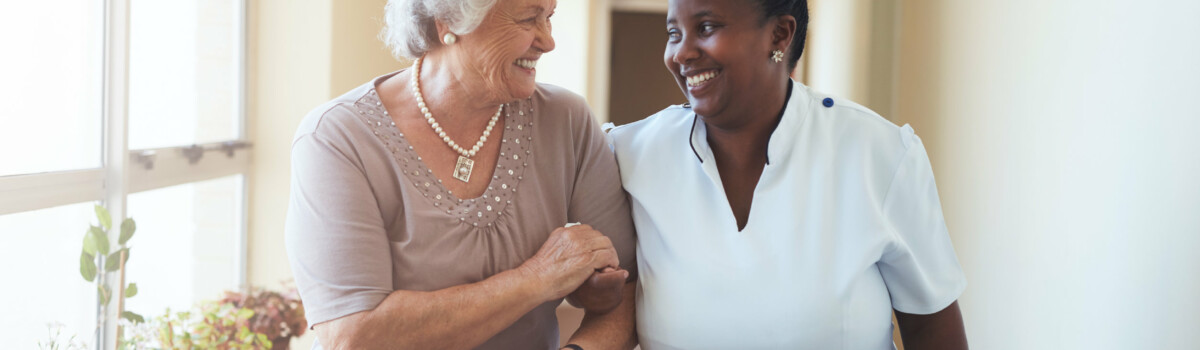 Nurse and elderly lady talking happily together