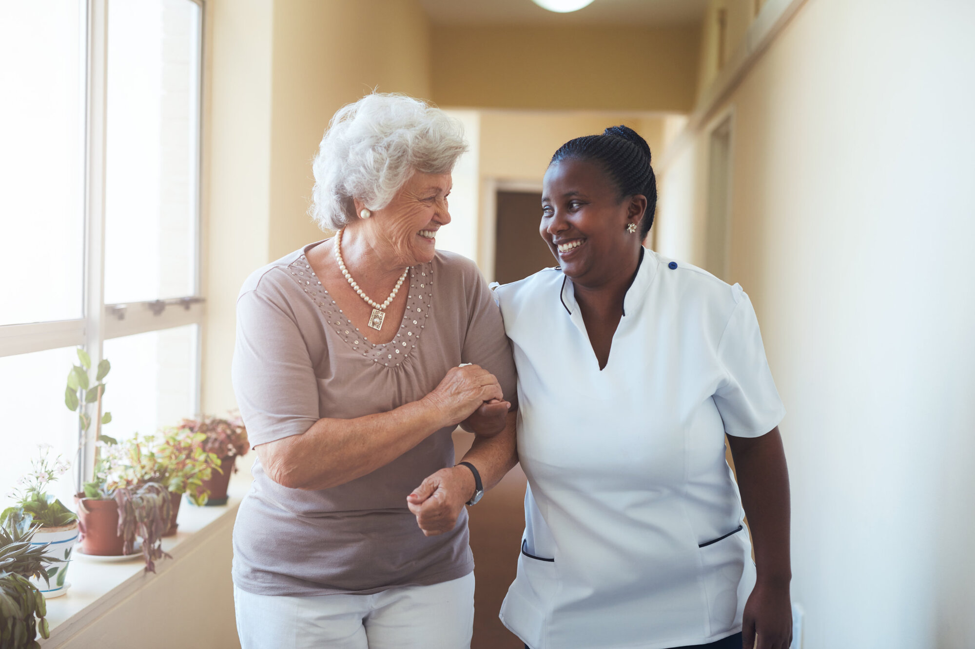 Nurse and elderly lady talking happily together Nurse and elderly lady talking happily together