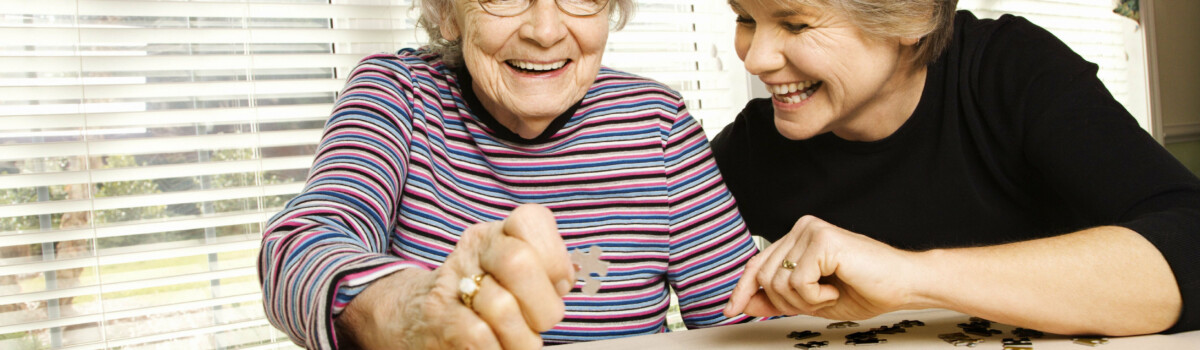 Elderly woman doing a jigsaw with her daughter