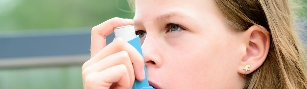 Girl who has asthma using her inhaler