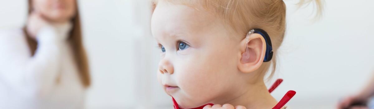 Toddler wearing hearing aid.