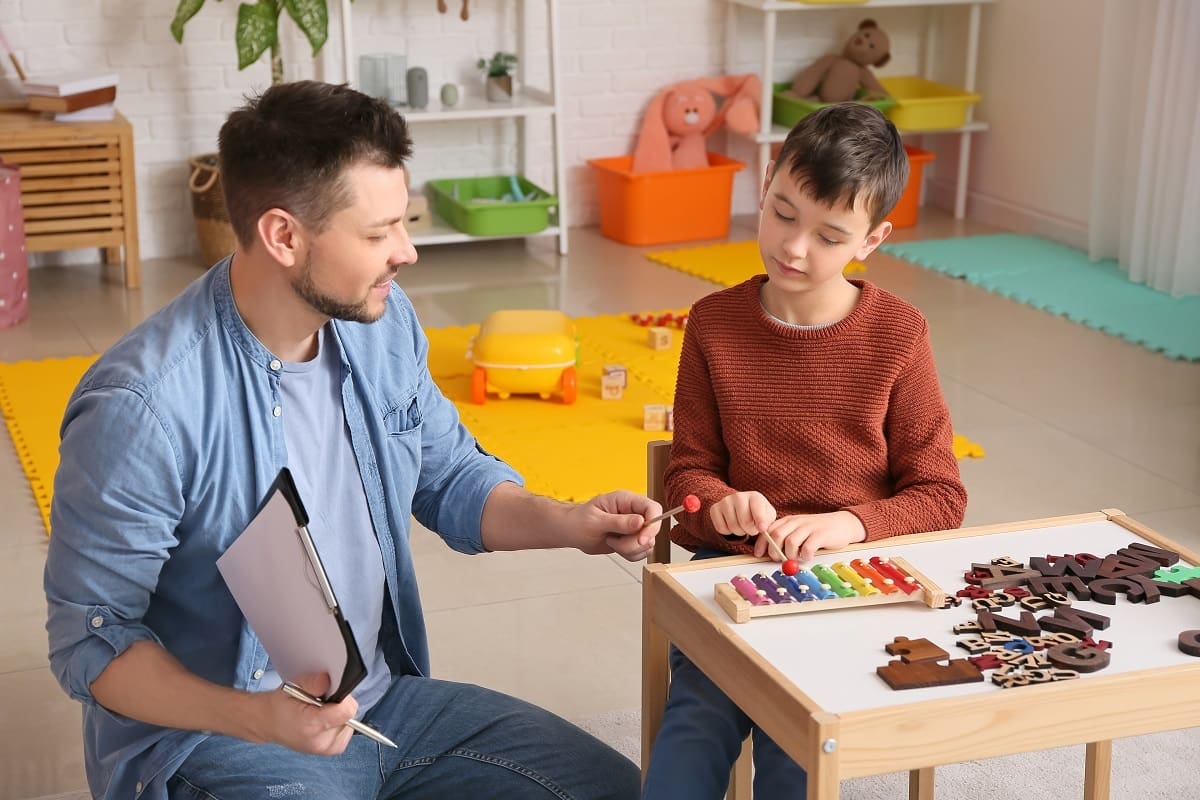 Therapist helping child with learning difficulties Therapist helping child with learning difficulties